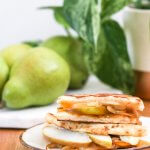 Vegan grilled cheese sandwich with pears and a plant in the background