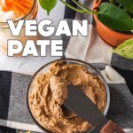 vegan pate on a black and white tablecloth with pickled carrots and daikon and a pothos