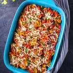 Tofu ricotta stuffed shells in a baking pan topped with sauce and vegan cheese with recipe title
