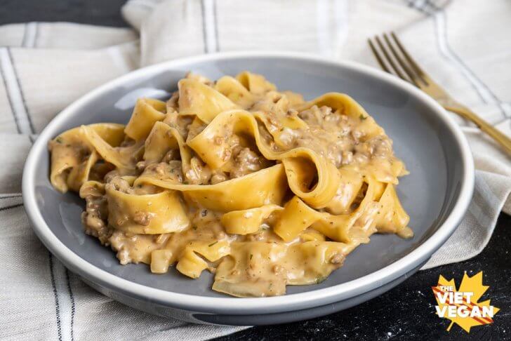 a serving of the finished pasta on a grey plate, on top of a beige plaid tea towel