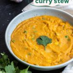 soup in a wide, shallow bowl, garnished with a cilantro leaf on a dark background, surrounded by garlic, a spoon, a tea towel, and cilantro, with "