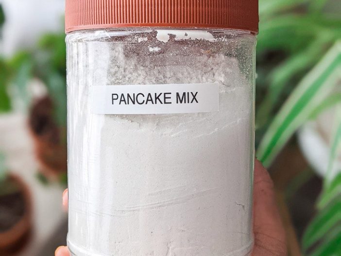 dry vegan pancake mix in a tub with "pancake mix" label on it