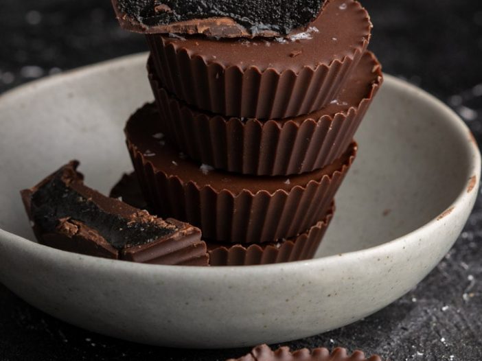 black sesame butter cups stacked, with three halves split and placed around the stack.