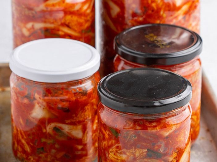 5 jars of kimchi fermenting on a baking tray