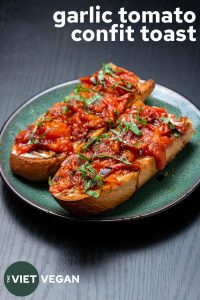 two pieces of toast with garlic tomato confit and text in the corner