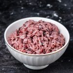 purple rice in a rice bowl, centered on a dark background