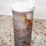 basil seed and malva nut drink in a to go cup on the counter