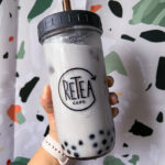 taro milk bubble tea in a reuseable glass in front of a terrazzo background
