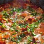 vegan tomato egg in a large wok made with fried bean curd and topped with scallions