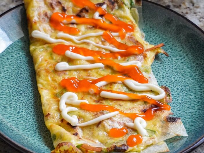 folded over banh trang nuong chay topped with vegan kewpie mayo and Vietnamese chili sauce