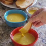 a toast stick dipped into the vegan egg yolk sauce