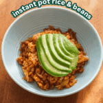 tomato rice and beans in a blue bowl with avocado fanned on top