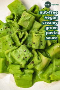 heart shaped pasta in a creamy green pasta sauce on a cream coloured plate