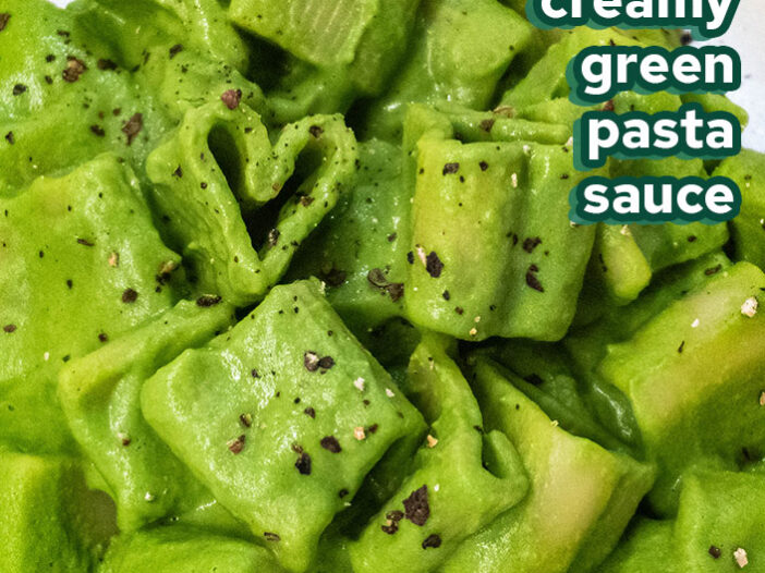 heart shaped pasta in a creamy green pasta sauce on a cream coloured plate
