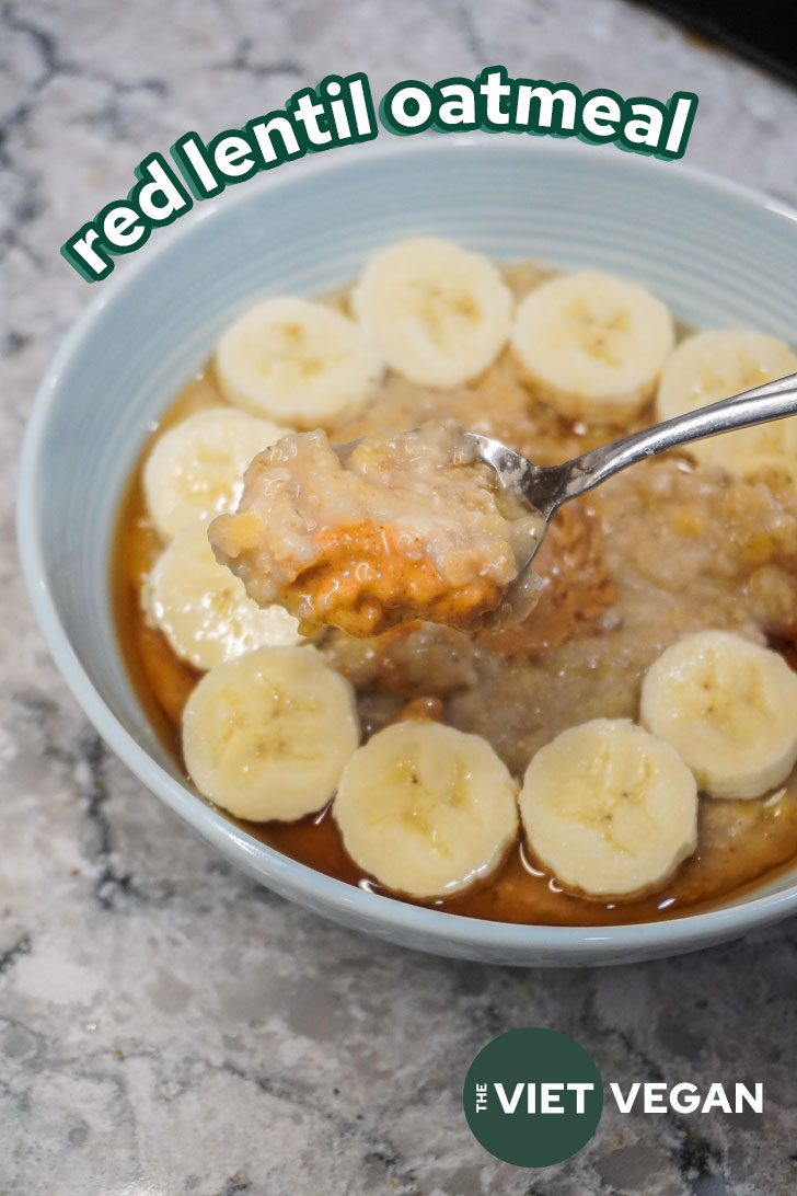 a blue bowl filled with red lentil oats, topped with banana and maple syrup. A spoonful of oatmeal with peanut butter over the bowl.