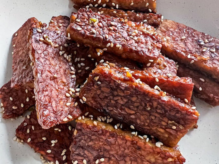 Bulgogi tempeh in a pan, garnished with sesame seeds
