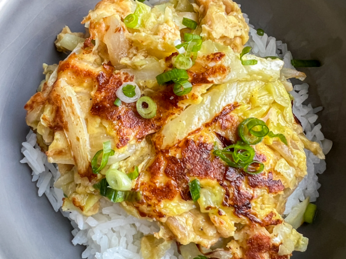 The finished oyakodon dish is served over rice, with sauce, in a bowl