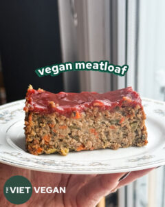 a slice of vegan meatloaf on a plate with a spicy ketchup glaze on top with the words "vegan meatloaf" overhead